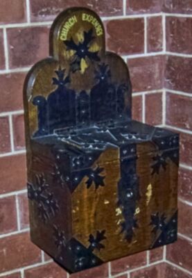 Alms box affixed to west wall of chapel